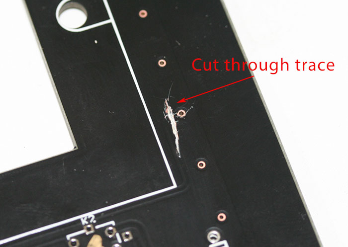 This is on the top/component side of the PCB.  Don't be shy about cutting it.